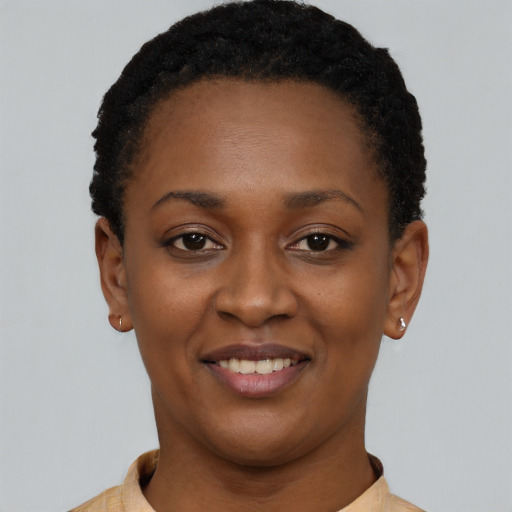 Joyful black young-adult female with short  black hair and brown eyes