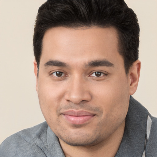 Joyful white young-adult male with short  black hair and brown eyes