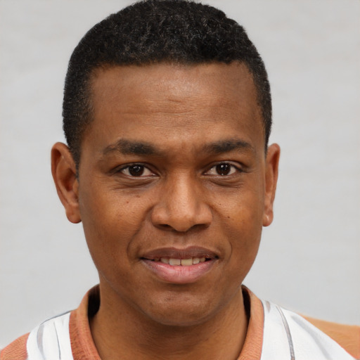 Joyful black young-adult male with short  brown hair and brown eyes