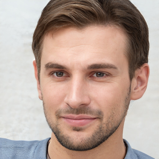 Joyful white young-adult male with short  brown hair and grey eyes