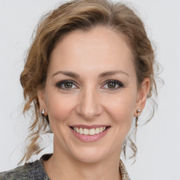 Joyful white young-adult female with medium  brown hair and grey eyes