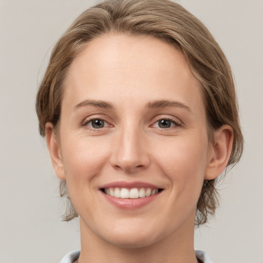 Joyful white young-adult female with medium  brown hair and grey eyes