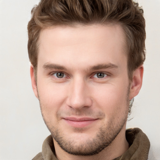 Joyful white young-adult male with short  brown hair and grey eyes