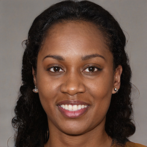 Joyful black young-adult female with long  black hair and brown eyes
