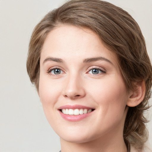 Joyful white young-adult female with medium  brown hair and green eyes