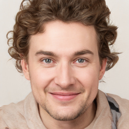 Joyful white young-adult male with short  brown hair and blue eyes