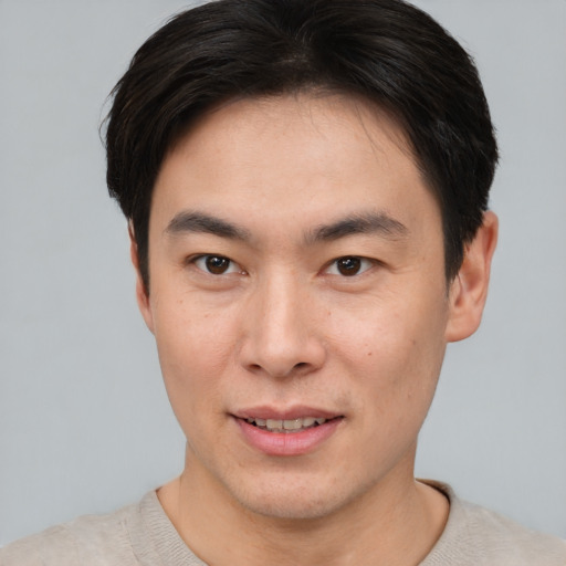 Joyful asian young-adult male with short  brown hair and brown eyes