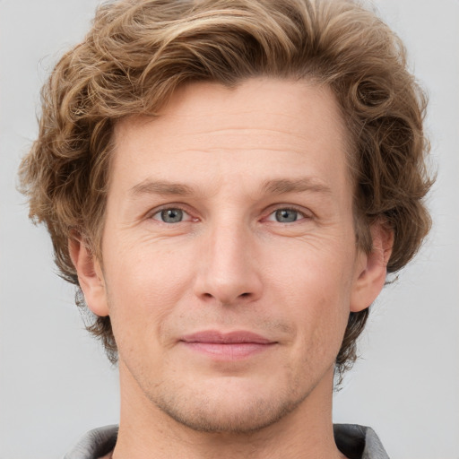 Joyful white adult male with short  brown hair and grey eyes