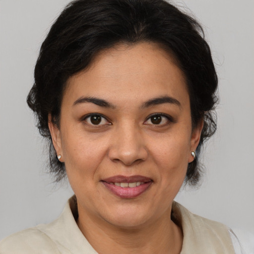 Joyful latino adult female with medium  brown hair and brown eyes
