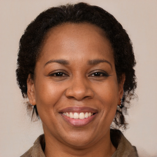 Joyful black adult female with long  brown hair and brown eyes