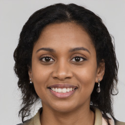 Joyful black young-adult female with long  brown hair and brown eyes