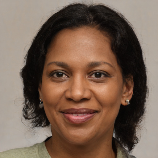 Joyful black adult female with medium  brown hair and brown eyes
