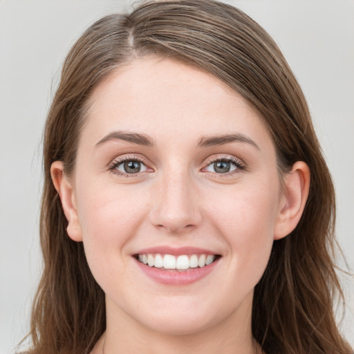 Joyful white young-adult female with long  brown hair and blue eyes