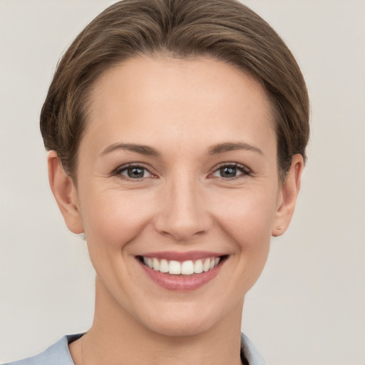 Joyful white young-adult female with short  brown hair and grey eyes