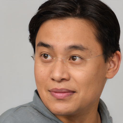 Joyful asian adult male with short  brown hair and brown eyes