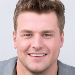 Joyful white young-adult male with short  brown hair and grey eyes