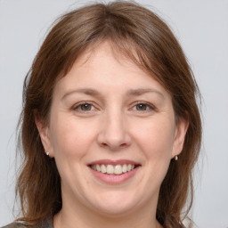 Joyful white adult female with medium  brown hair and grey eyes