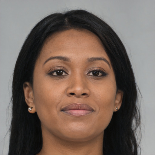 Joyful black young-adult female with long  brown hair and brown eyes