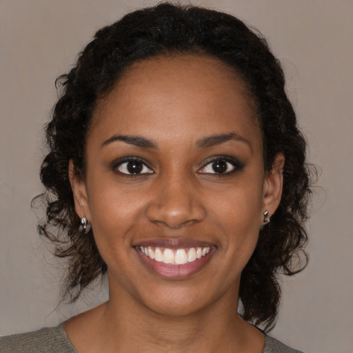 Joyful black young-adult female with medium  brown hair and brown eyes