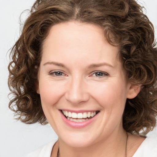 Joyful white young-adult female with medium  brown hair and green eyes