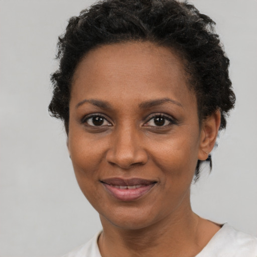 Joyful black adult female with short  brown hair and brown eyes