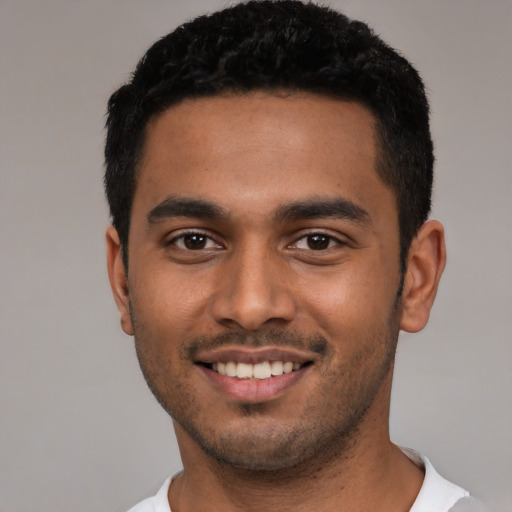Joyful latino young-adult male with short  black hair and brown eyes
