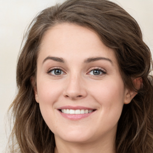 Joyful white young-adult female with long  brown hair and green eyes