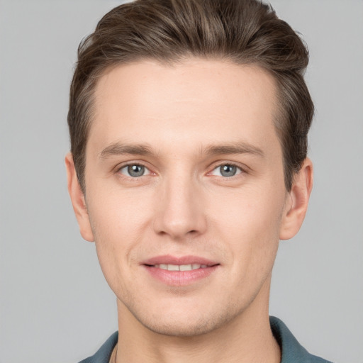 Joyful white young-adult male with short  brown hair and grey eyes