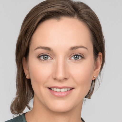 Joyful white young-adult female with medium  brown hair and grey eyes