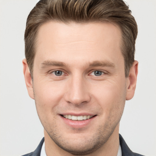 Joyful white young-adult male with short  brown hair and grey eyes