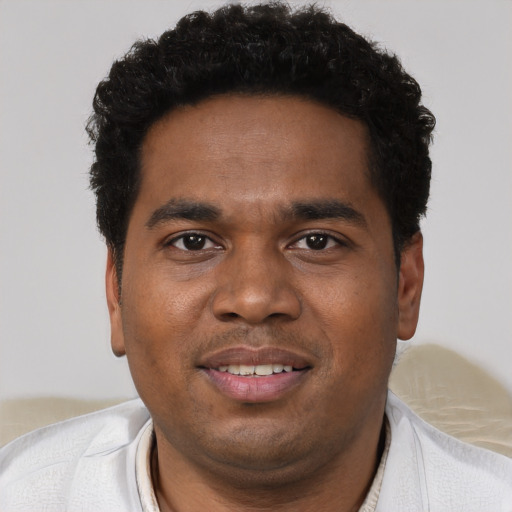 Joyful black young-adult male with short  black hair and brown eyes