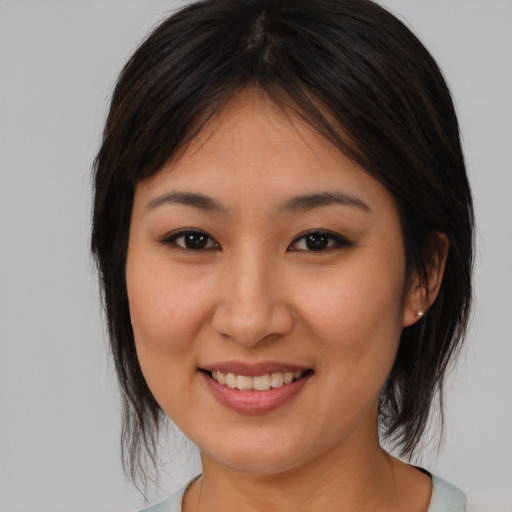 Joyful asian young-adult female with medium  brown hair and brown eyes