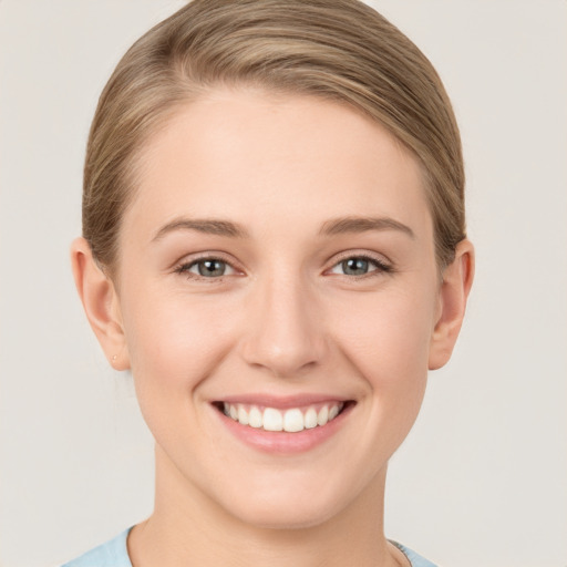 Joyful white young-adult female with short  brown hair and grey eyes