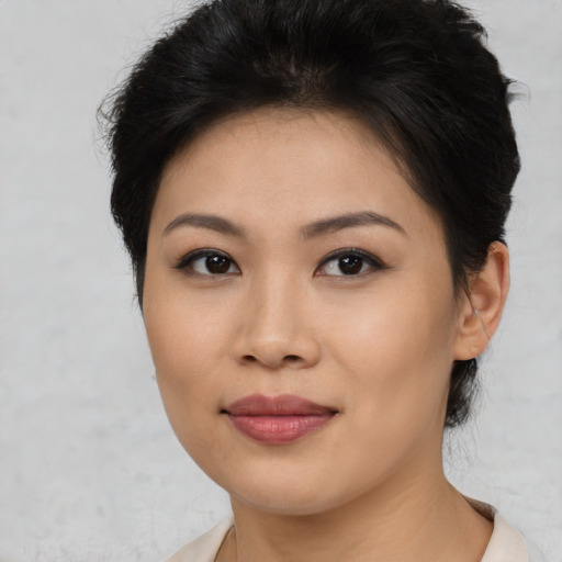 Joyful asian young-adult female with short  brown hair and brown eyes