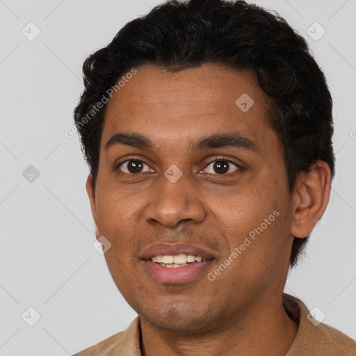 Joyful black young-adult male with short  brown hair and brown eyes