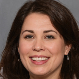 Joyful white adult female with long  brown hair and brown eyes