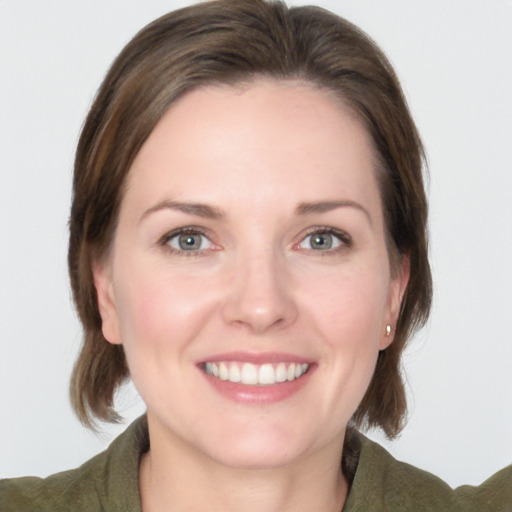 Joyful white young-adult female with medium  brown hair and grey eyes