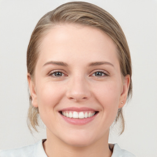 Joyful white young-adult female with medium  brown hair and blue eyes