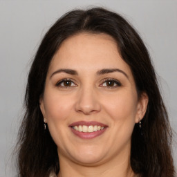 Joyful white adult female with long  brown hair and brown eyes