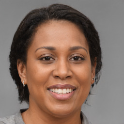 Joyful latino adult female with medium  brown hair and brown eyes