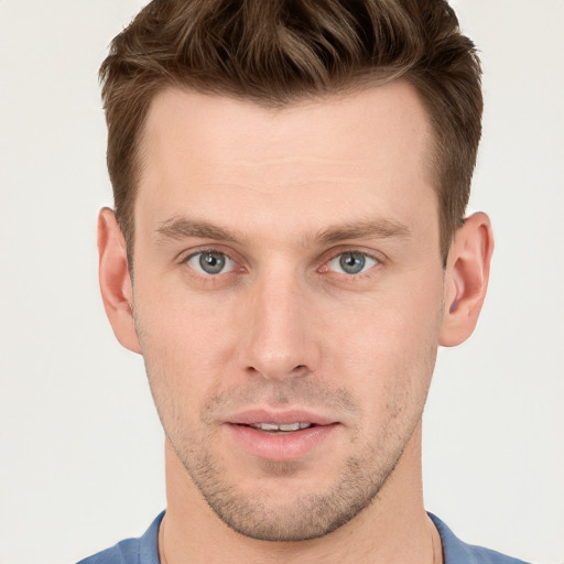 Joyful white young-adult male with short  brown hair and grey eyes