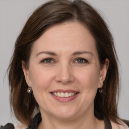 Joyful white adult female with medium  brown hair and grey eyes