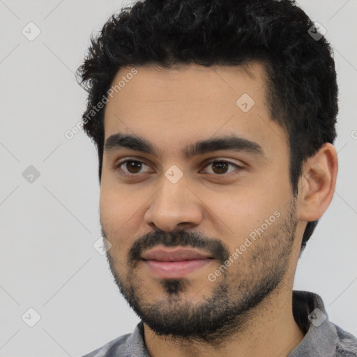 Joyful latino young-adult male with short  black hair and brown eyes