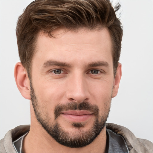 Joyful white young-adult male with short  brown hair and grey eyes