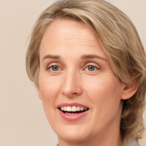 Joyful white adult female with medium  brown hair and green eyes