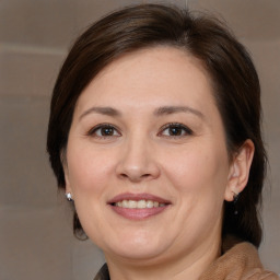 Joyful white adult female with medium  brown hair and brown eyes