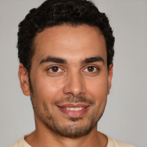 Joyful latino young-adult male with short  brown hair and brown eyes