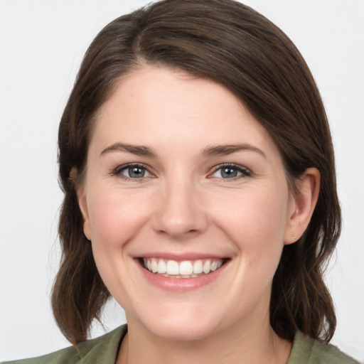 Joyful white young-adult female with medium  brown hair and grey eyes