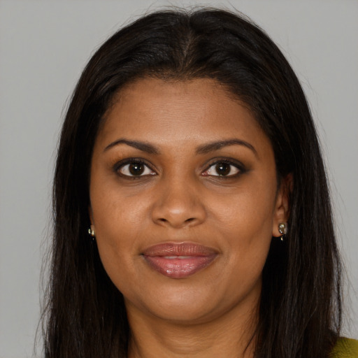 Joyful black young-adult female with long  brown hair and brown eyes