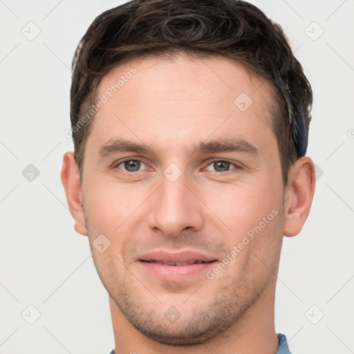 Joyful white young-adult male with short  brown hair and brown eyes